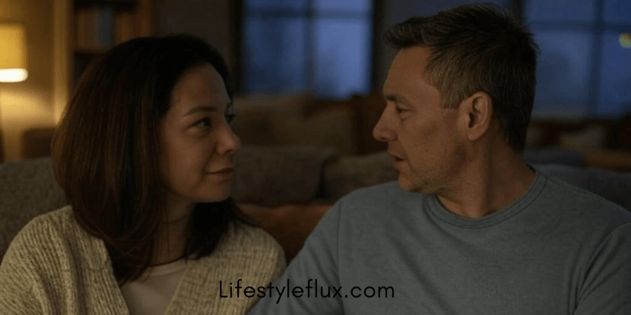 A man and a woman, who appear to be middle-aged, are looking at each other in a softly lit indoor setting.